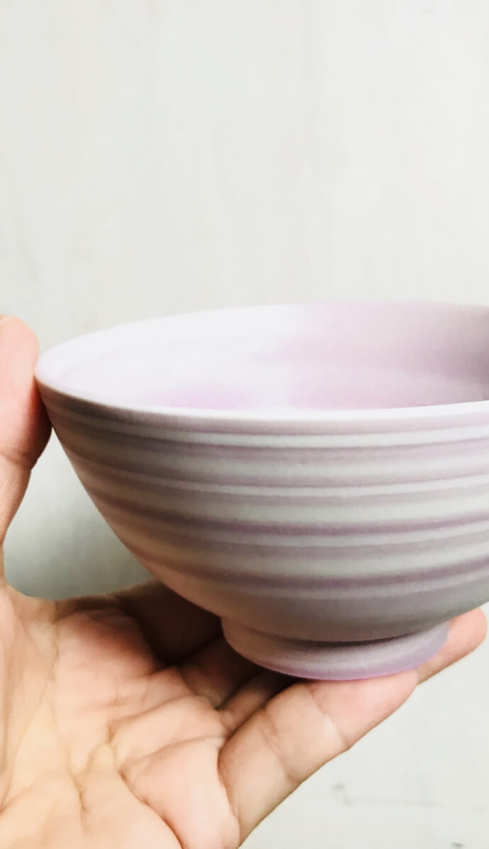 スパイラル練り込み陶芸作品、白い素材に濃淡それぞれのピンク紫が練り込まれている